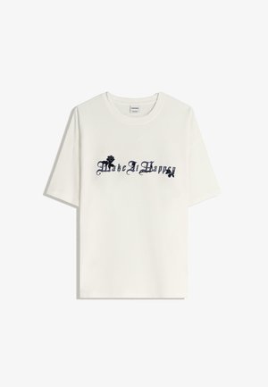Witte katoenen T-shirt met een zwart bloemenpatroon en de tekst "Make It Happen" in gestileerde lettertype op de voorkant. Korte mouwen.
