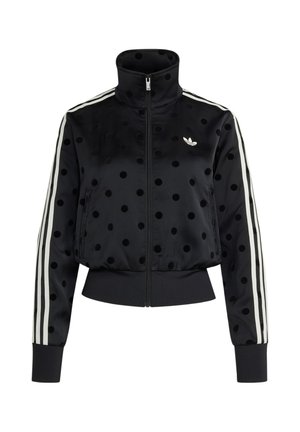 Μαύρο τζάκετ με φερμουάρ και μαύρες πουά, λευκό λογότυπο Adidas στο στήθος και λευκές τρεις ρίγες κατά μήκος των μανικιών.