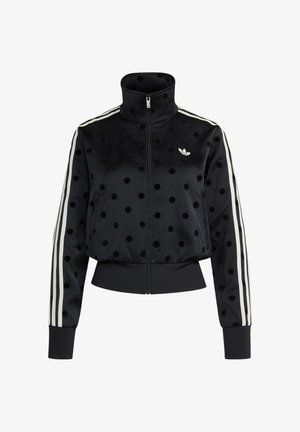 Veste noire zippée avec des pois noirs, logo Adidas blanc sur la poitrine et trois bandes blanches courant le long des manches.