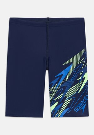 Μπλε ναυτικό μαγιό τύπου jammer με μπλε, πράσινο ζιγκ-ζαγκ σχέδιο και λογότυπο Speedo στο δεξί μηρό.