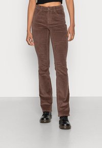 Pantalon en velours côtelé marron avec un design à jambes droites, doté d'une fermeture à bouton, de passants de ceinture et d'une texture de côtes verticales subtiles.