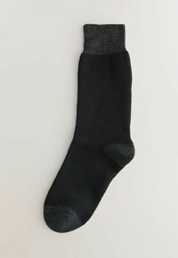 Calcetín negro con un puño y una puntera en un gris oscuro contrastante. Hecho de una tela suave, con una textura lisa y un diseño clásico.