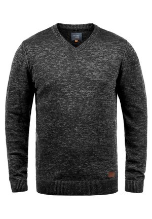 Suéter gris oscuro con cuello en V, mangas largas, puños y dobladillo de canalé, patrón de tejido texturizado y un pequeño parche de cuero con logo en la parte inferior.