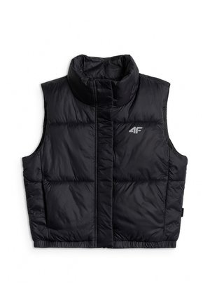 Meisje staat met handen achter haar rug, draagt een roze muts, een zwart pufferjack, een wit shirt met lange mouwen, felroze joggingbroek en witte sneakers.