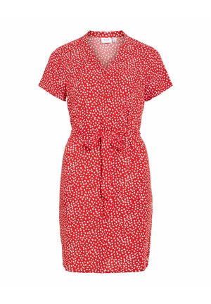 Červené krátke šaty s bielymi nepravidelnými bodkami, výstrih do V, zapínanie na gombíky vpredu a opasok viazaný v páse.