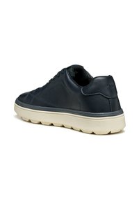 Zapatilla de cuero navy con suela de goma beige, puntera redondeada y cordones planos. Presenta una textura suave y un diseño minimalista.