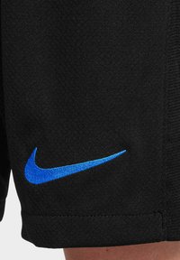 Shorts de sport noirs en tissu texturé, arborant un logo Nike brodé bleu sur le bas à gauche.