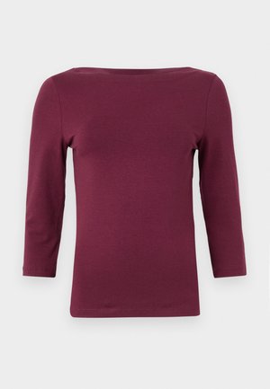 Burgundy long-sleeve top with a boat neckline, made from soft, stretchy fabric. Features a fitted shape and subtle hemline detailing.