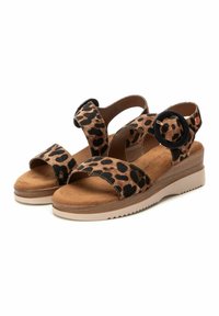 Sandalias de estampado de leopardo con dos correas anchas, un detalle de hebilla circular, textura de ante suave y suela en cuña en tonos beige y marrón.