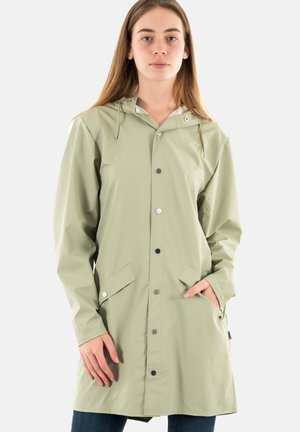 Giacca a vento impermeabile verde chiaro con cappuccio, bottoni a pressione e tasche laterali. Texture liscia con un design che arriva a metà coscia.