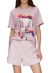 Lichtroze katoenen t-shirt met bloemenprint en zilveren tekst, gecombineerd met lichtgestreepte shorts met een elastische tailleband.