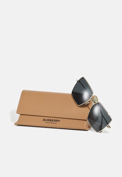 Ochelari de soare Burberry cu lentile negre unghiulare, accesorii aurii și o husă din piele bej cu numele mărcii gravat în negru.
