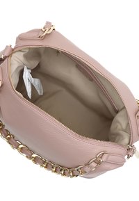 Lichtroze leren handtas met een geaccentueerd oppervlak, gouden hardware, schakels op de schouderriem en een ruime beige binnenkant.