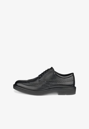 Miesten musta nahkainen wingtip-broguekengät, joissa on rei'itetyt koristekuviot ja nauhakiinnitys, nähtynä ulkopuolelta.