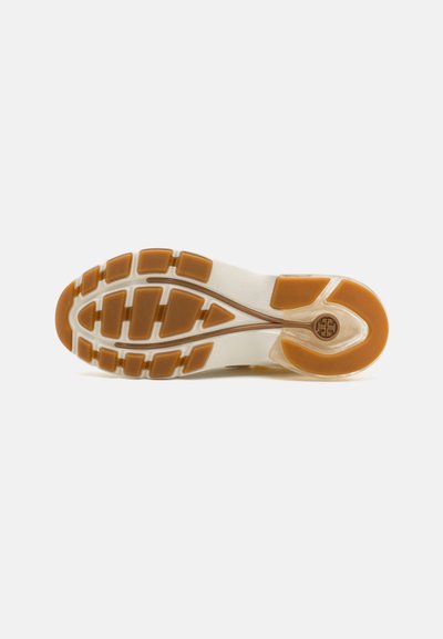 Sola di una scarpa con un'intersuola bianca flessibile e una suola in gomma marrone testurizzata che presenta un motivo geometrico e dettagli del logo.