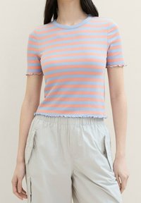 Camiseta de punto acanalado con rayas rosas y azul claro, escote redondo y dobladillos y mangas con volantes. Combina con pantalones elásticos gris claro.