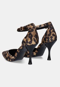 Zapatos de tacón alto con estampado de leopardo, punta afilada, correa al tobillo y tacón de aguja negro. Material de ante suave con una textura lisa.