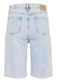 Světle modré denimové šortky s volným střihem, roztrhanými okraji a dvěma zadními kapsami. Mají béžovou nášivku na pase.