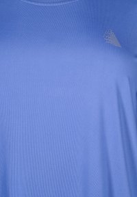 Lichtblauw kortom shirt met een gladde structuur en ronde halslijn, met een subtiel geometrisch patroon op de bovenste rechterkant.