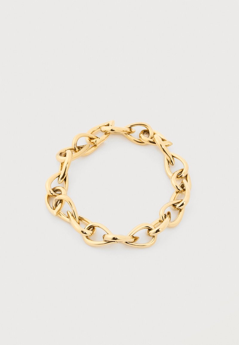 Βραχιόλι με αλυσίδα σε χρυσό τόνο με μεγάλους, ακανόνιστους οβάλ κρίκους διατεταγμένους σε κυκλικό σχήμα πάνω σε απλό ανοιχτό φόντο.