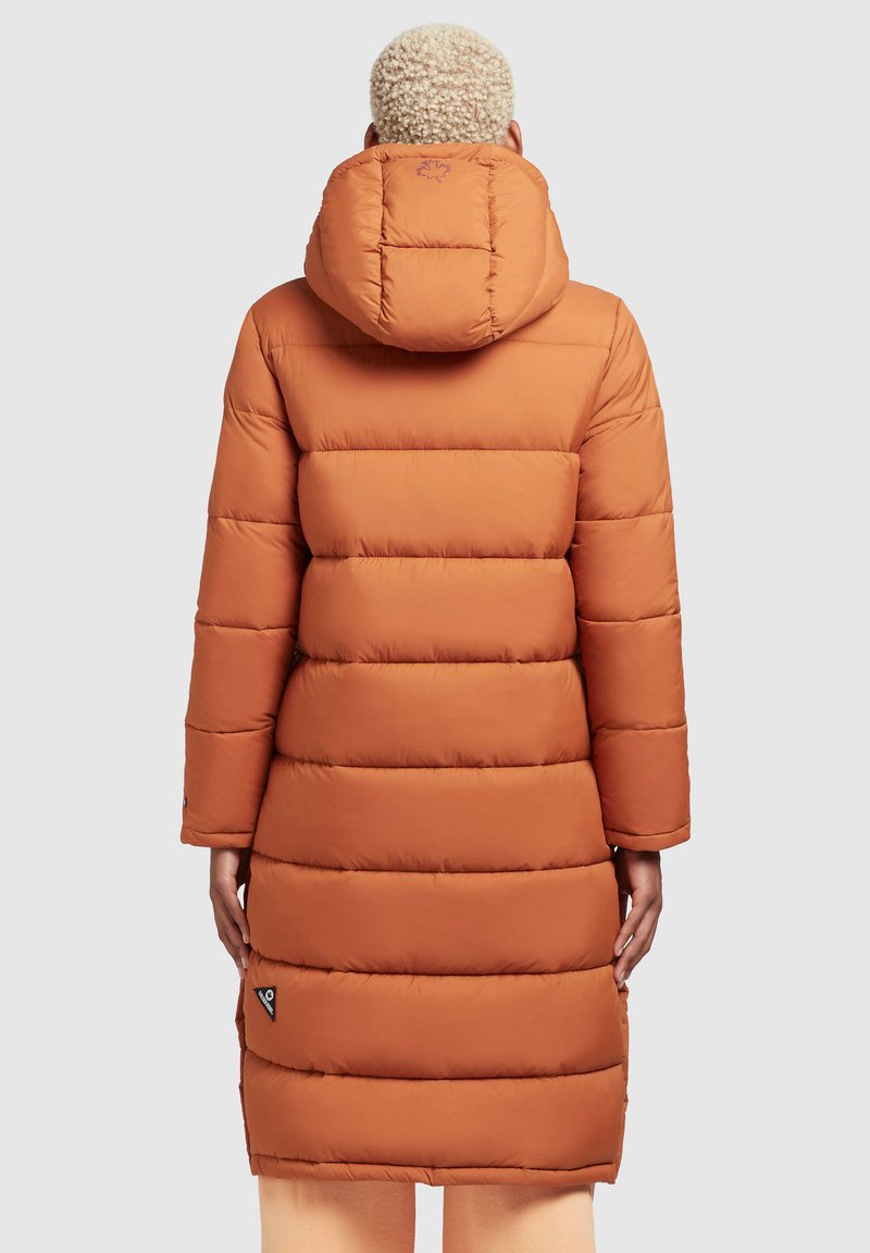 Langer Puffer-Mantel in verbranntem Orange mit horizontalem Steppmuster, Kapuze und Logopatch nahe dem Saum. Glatte Textur, warmes Material.