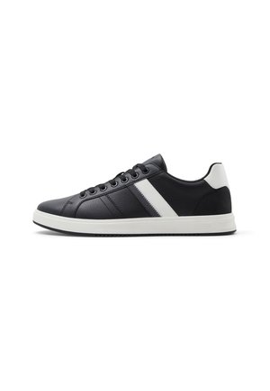 Zapatillas negras con parte superior de cuero texturizado, detalle de franjas blancas y talón blanco en contraste. Cuenta con cordones redondos y suela de goma.