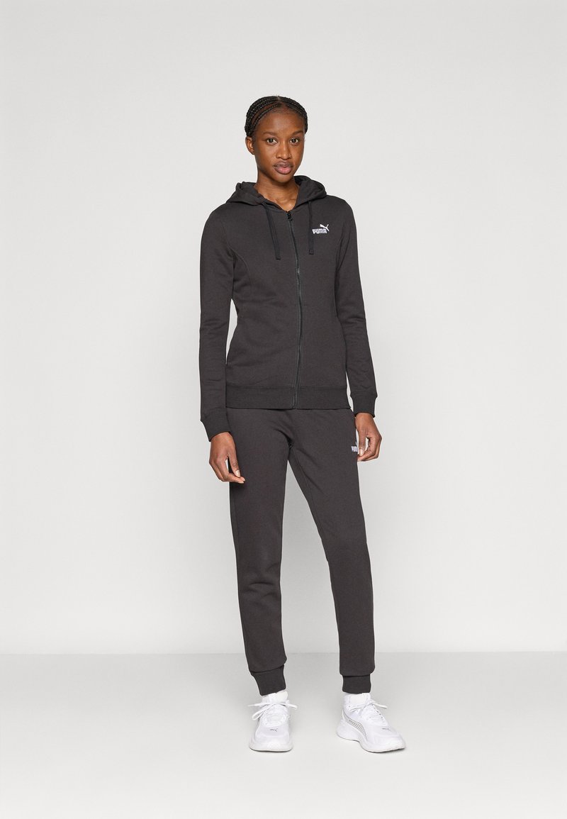 Μαύρο φούτερ με φερμουάρ και κουκούλα με κορδόνι, με γκρίζο λογότυπο, σε συνδυασμό με τζόγκερ που ταιριάζουν. Και τα δύο έχουν ριμπ μανσέτες και απαλή υφή.