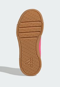 Adidasova potplata tenisice s teksturiranom svijetlosmeđom gumom i kružnim uzorcima; istaknuta ružičastim bočnim panelom i detaljima marke.