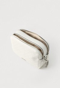 Bijela teksturirana kozmetička torbica s dva pretinca na patentni zatvarač, srebrnim metalnim dijelovima i lancem kao detaljem. Glatka unutrašnja podstava u bež tonu.