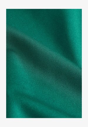 Tume roheline kangas, sile tekstuur ja peen ribastus, laskub pehmelt, näidates elavat värvi ilma mustrite või kaunistusteta.