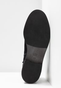 Semelle d'une chaussure en cuir noir taille 4½ avec le tampon visible « Cuir Véritable All Leather Vero Cuoio ».