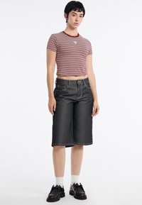 Pasiastry w burgundzie i kremie, skrócony t-shirt zestawiony z ciemnoniebieskimi kulotami z kontrastowym przeszyciem oraz klasycznym pięciokomorowym wzorem.