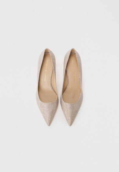 Beige pointed-toe pumps with a textured, sparkly material and smooth interior. Features a low-cut design and a smooth finish.