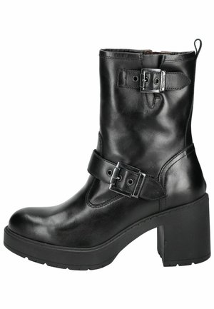 Black leather ankle boot with a rounded toe, chunky block heel, dual buckle accents, and a zipper closure on the side.