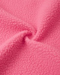 Rosa fleece-stoff med en teksturert overflate, som har en myk, plysj-følelse og en jevn farge gjennom hele, foldet i en virvel.