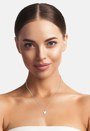 Silberne Kettenhalskette mit einem kleinen herzförmigen Anhänger. Glatte, polierte Oberfläche. Das Modell hat einen freien Hals, was das Design der Halskette betont.