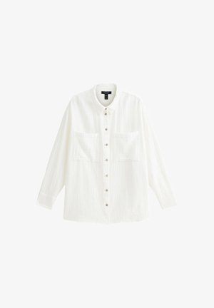 Chemise blanche à boutons en tissu texturé, dotée d'un col, de deux poches poitrine et de manches longues avec des poignets à boutons.