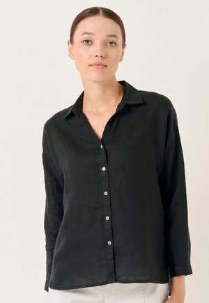 Black linen button-up shirt with a collared neckline, long sleeves, and iridescent buttons, featuring a relaxed fit and soft texture.