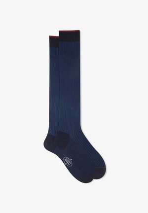 Calze blu navy, al ginocchio, con sottili righe verticali, punte rinforzate e un accentuato contrasto scuro nella parte superiore. Finitura strutturata e liscia.