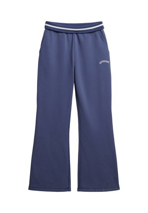 Blå sweatpants med vide ben og elastisk taljebånd med to hvide striber og "Superdry"-logo på venstre lår.