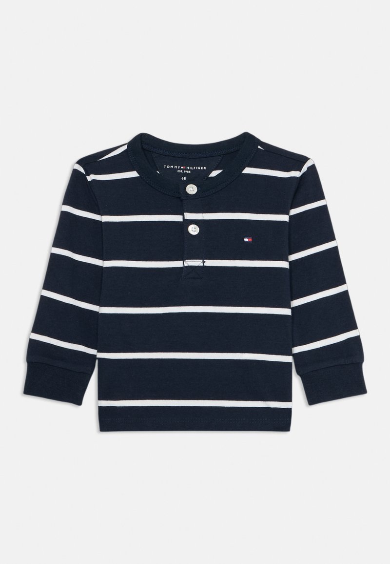 Maglietta a maniche lunghe color navy con strisce bianche, colletto rotondo, patta con due bottoni e piccolo logo sul petto. Materiale in cotone, texture morbida.
