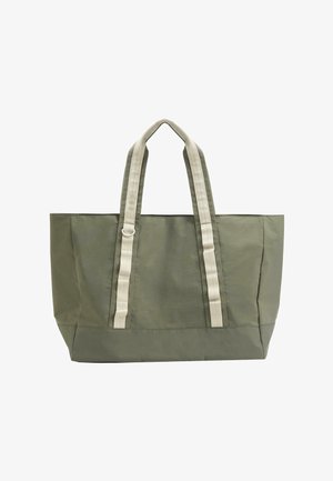 Grande borsa tote verde oliva con ampi doppi manici beige e un piccolo anello metallico su un manico.