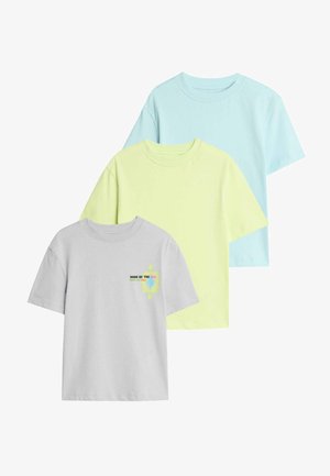 Drie T-shirts met korte mouwen: één grijs met grafische details, één lichtgeel en één lichtblauw. Gemaakt van zachte katoenen stof.