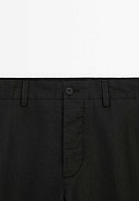Zwarte linnen broek met een flat front, met een enkele knoopsluiting, riemlussen en zijzakken. Glad textuur en op maat gemaakte snit.