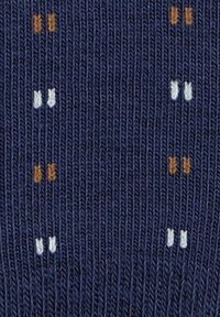 Granatowa tkanina z równomiernie rozmieszczonym małym haftem w kolorze pomarańczowym, białym i jasnoniebieskim, tworzącym geometryczny wzór na powierzchni.