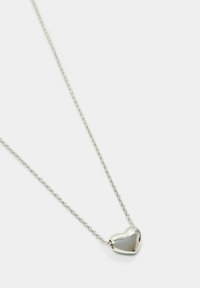 Collana con pendente a forma di cuore in argento, su una catena sottile, con una superficie liscia e lucida e un design a maglia delicato.