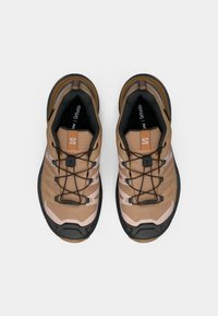 Καφέ και ροζ αθλητικά παπούτσια με υφή στο πάνω μέρος, μαύρες λεπτομέρειες, σχέδιο με κορδόνια και ενισχυμένο προστατευτικό μέρος μύτης. Φαίνεται η ενίσχυση Ortholite στο πέλμα.