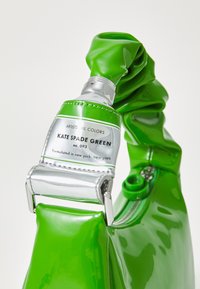 Zielona torebka z lakierowanej skóry z fakturowanym paskiem i srebrnym wykończeniem. Posiada metkę z napisem "KATE SPADE GREEN" oraz suwak i akcenty.