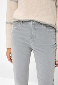 Graue Cord-Hose im slim Fit, mit fünf Taschen, einem vorderen Knopfverschluss und dezenten Stickdetails.