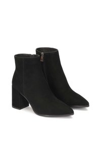 Botines de ante negros con punta afilada y tacón cuadrado ancho. Presentan cremallera lateral y textura suave.